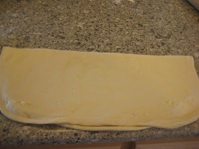 Pizza dough folded in half on countertop