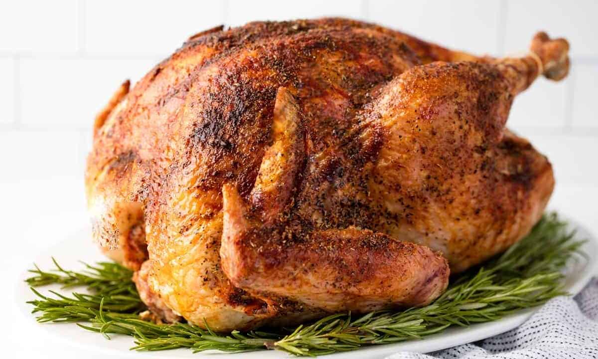 Turkey is sitting on a plate of rosemary.