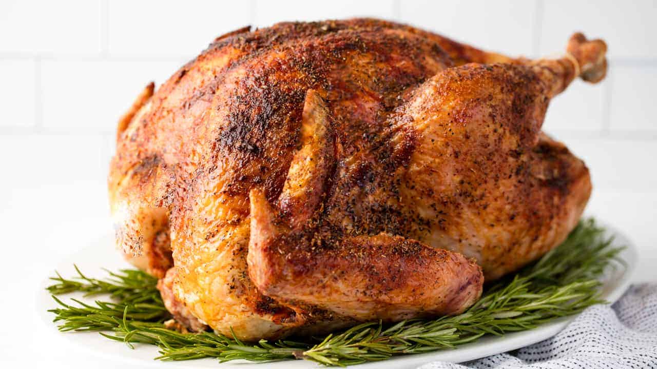 Turkey is sitting on a plate of rosemary.