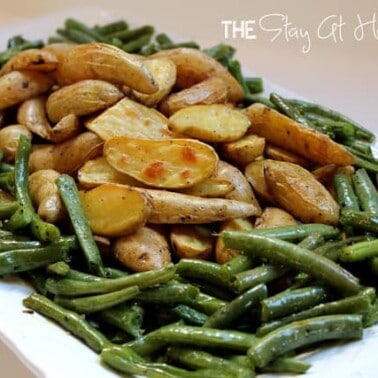 Potatoes and green beans on a white serving dish.
