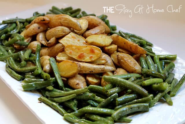 Potatoes and green beans on a white serving dish.