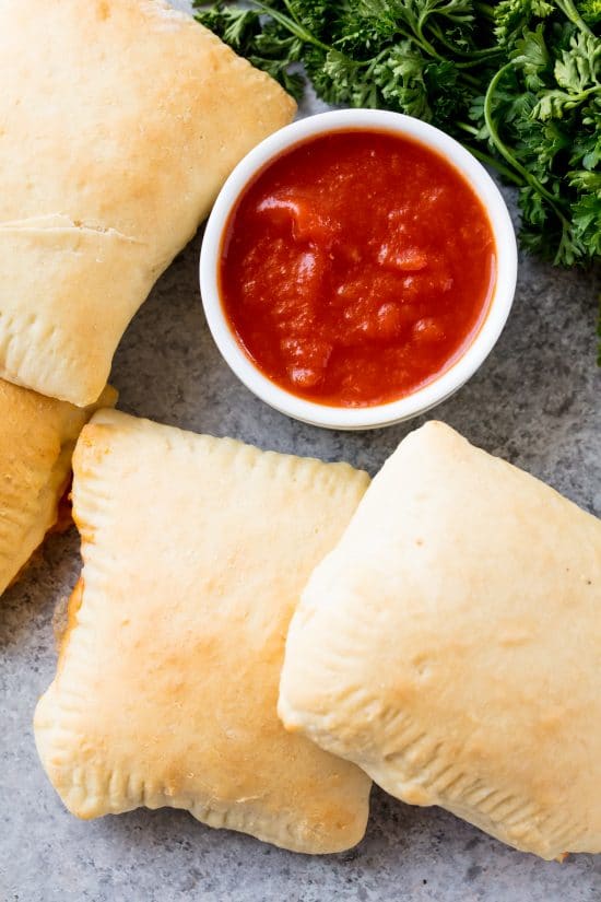 Tasche calde fatte in casa con una ciotola di salsa marinara da intingere