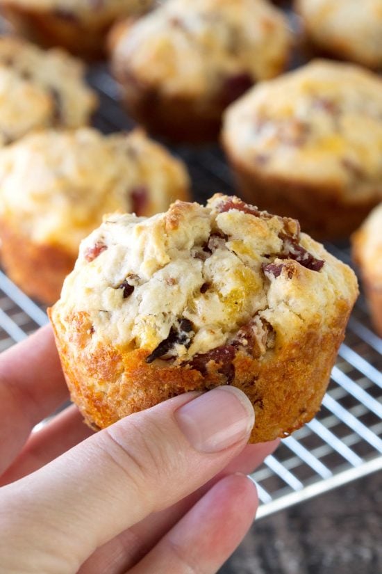 A hand holding up a Bacon Cheddar Muffin.