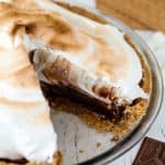 Homemade smores pie from scratch layered with graham cracker crust, hot fudge filling and topped with Italian meringue