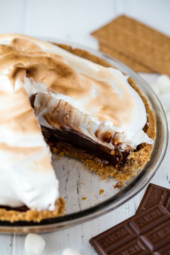 Homemade smores pie from scratch layered with graham cracker crust, hot fudge filling and topped with Italian meringue