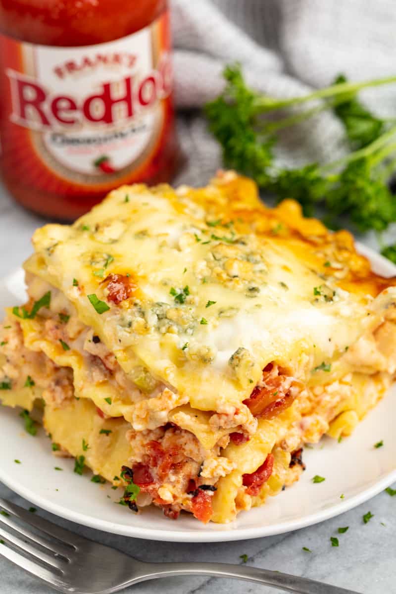 Slice of buffalo chicken lasagna on a white plate.