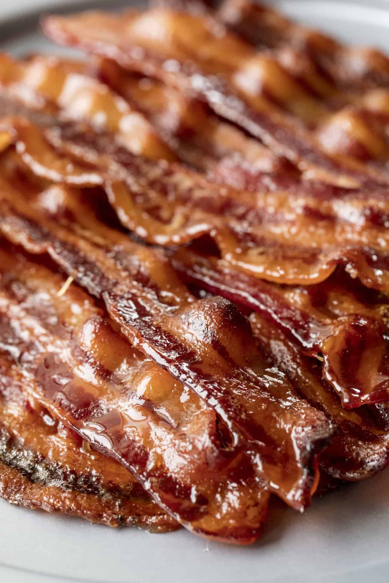  Close up of a stack of Candied Bacon to show maple syrup, brown sugar, cayenne pepper sauce on them.