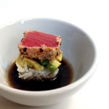 Ahi Avocado sushi in a bowl of soy sauce.