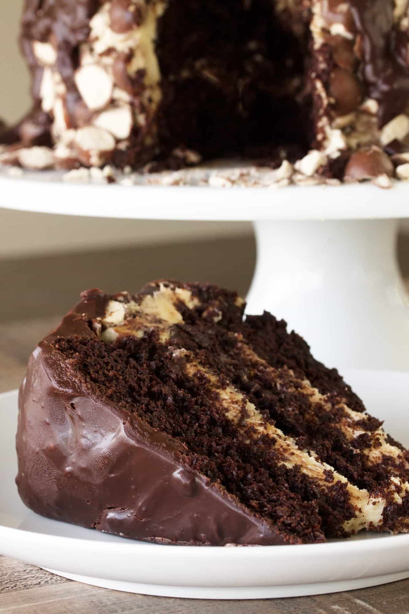 A slice of triple chocolate malt cake on a white plate. 