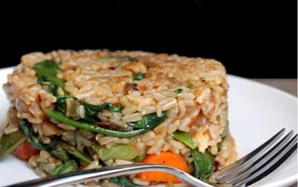 Healthy Fried Rice served up on a white plate with a fork on it.