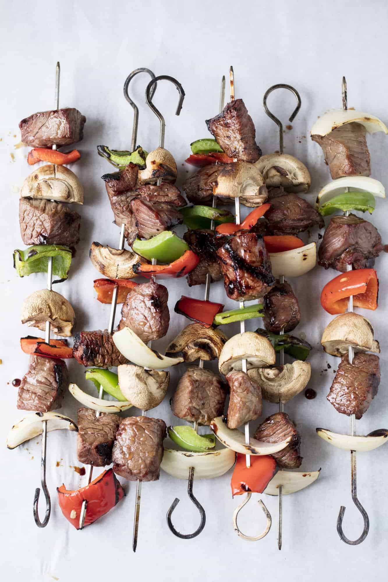 Chunks of beef, bell peppers, and mushrooms threaded onto 7 different skewers