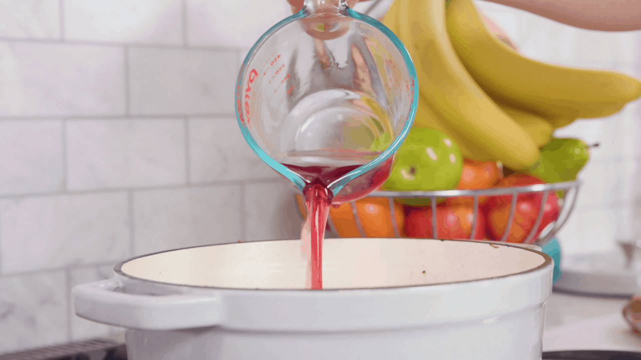 Pouring Cranberry Juice into Braised Lamb Shanks