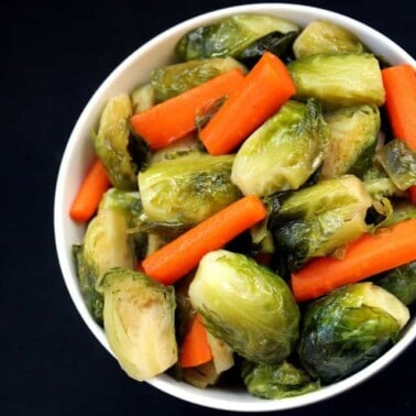 Maple Brussel Sprouts and carrots in a white bowl.