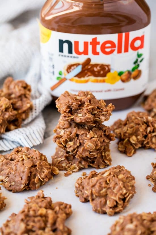 Peanut Butter Nutella No Bake Cookies stacked in front of a jar of nutella