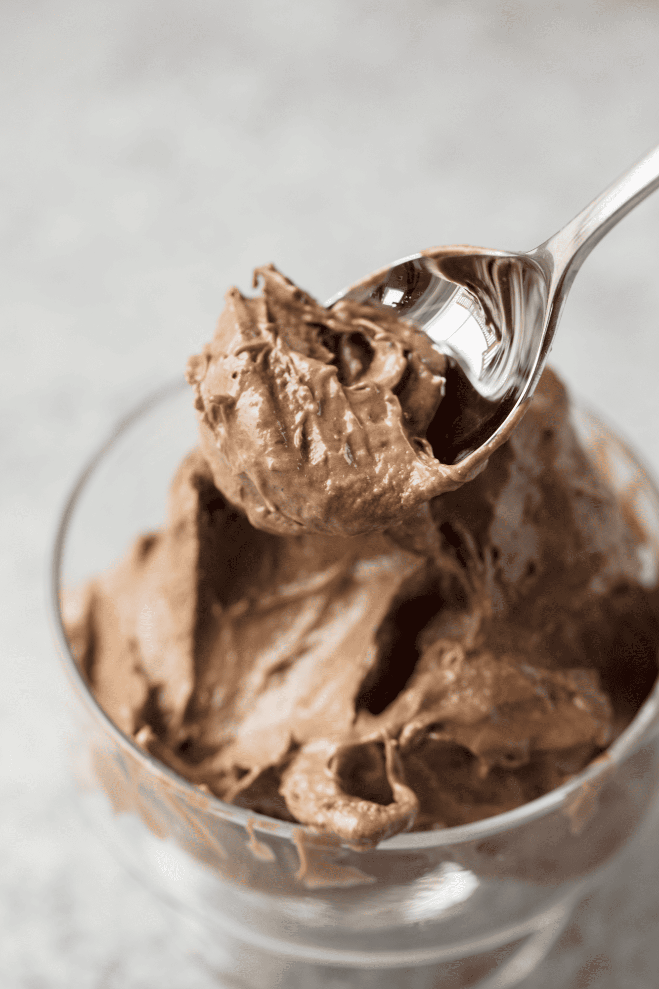 Close up of a spoon full of chocolate peanut butter banana ice cream to show texture. 