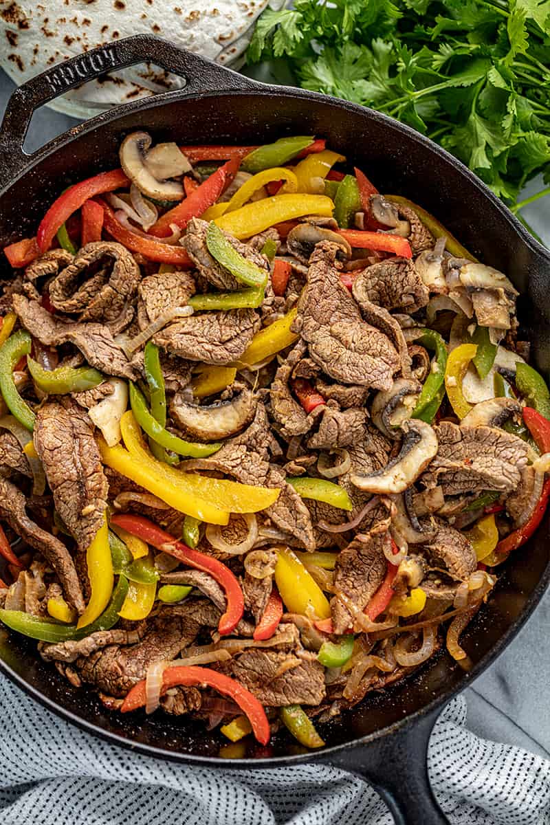 Bird's eye view of Steak Fajitas in a cast-iron skillet.