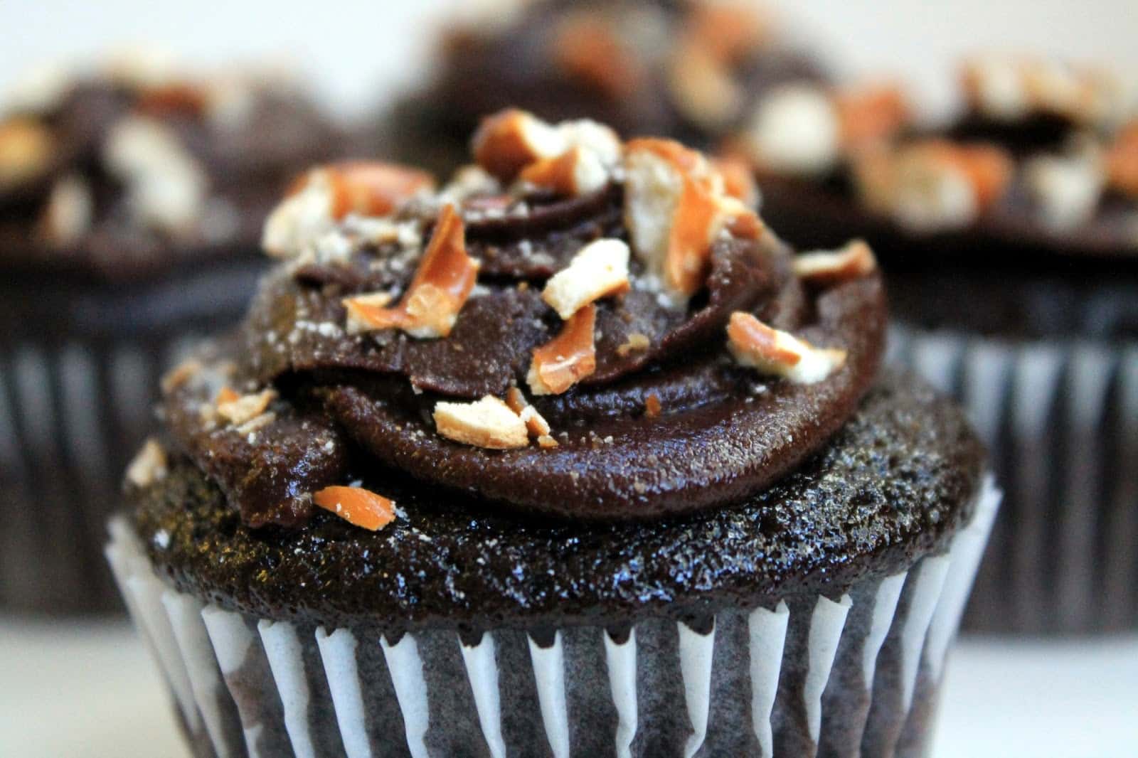 Sinfully decadent chocolate cupcakes filled with a creamy peanut butter filling and topped with whipped chocolate ganache and crushed pretzel.