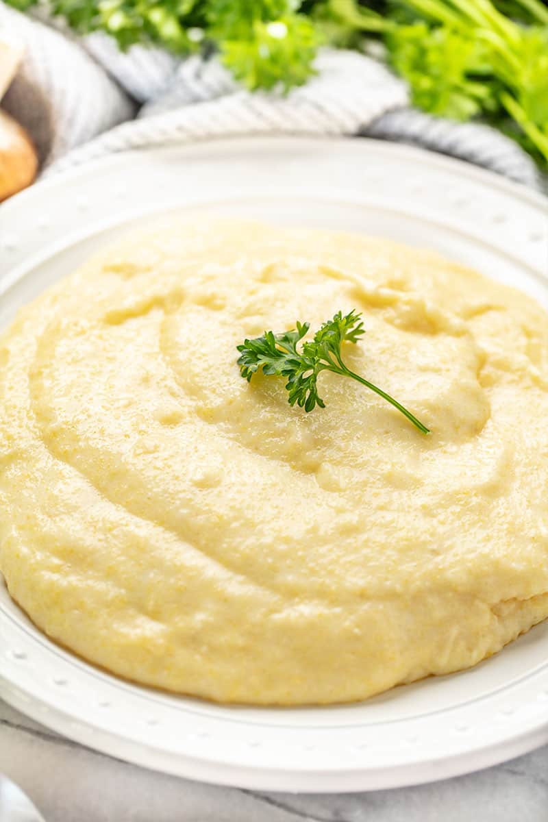 Close up of Polenta top with parlsey on a white plate.