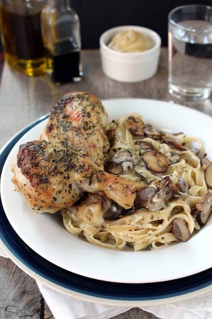 Tarragon Dijon roasted chicken with tarragon cream pasta  on a white plate with oil in the background