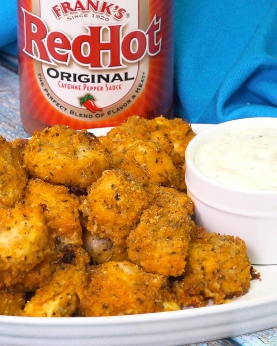 Buffalo Chicken Nuggets on a serving plate with a bowl of sauce. 