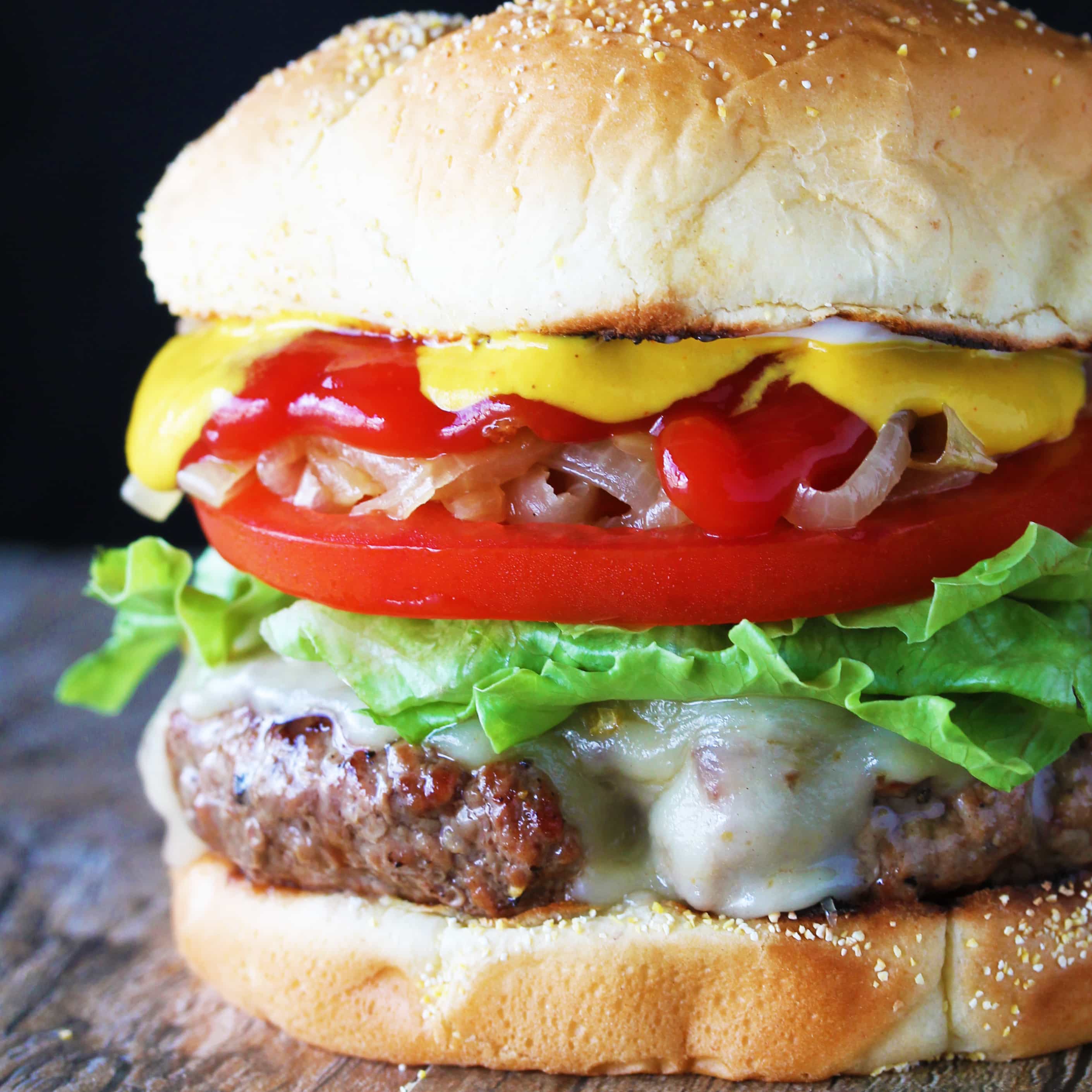 A burger sitting on a wood countertop.