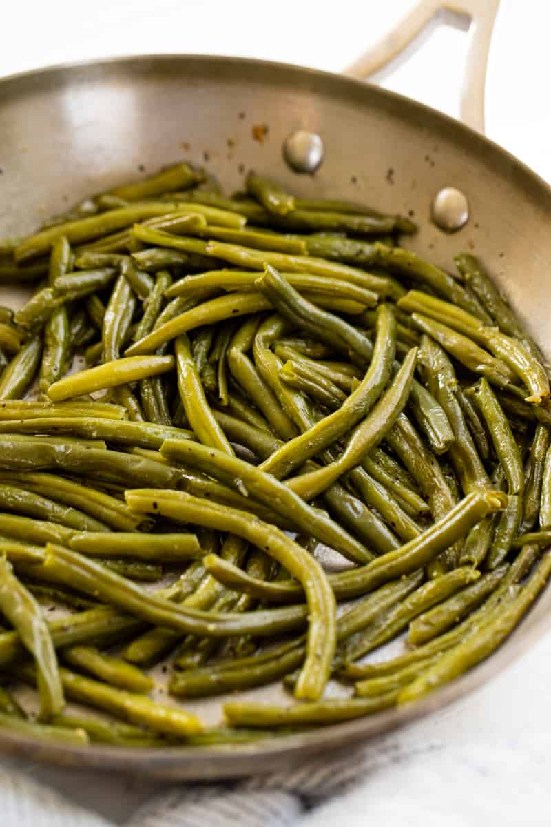 Cooked green beans in a stainless steel skillet