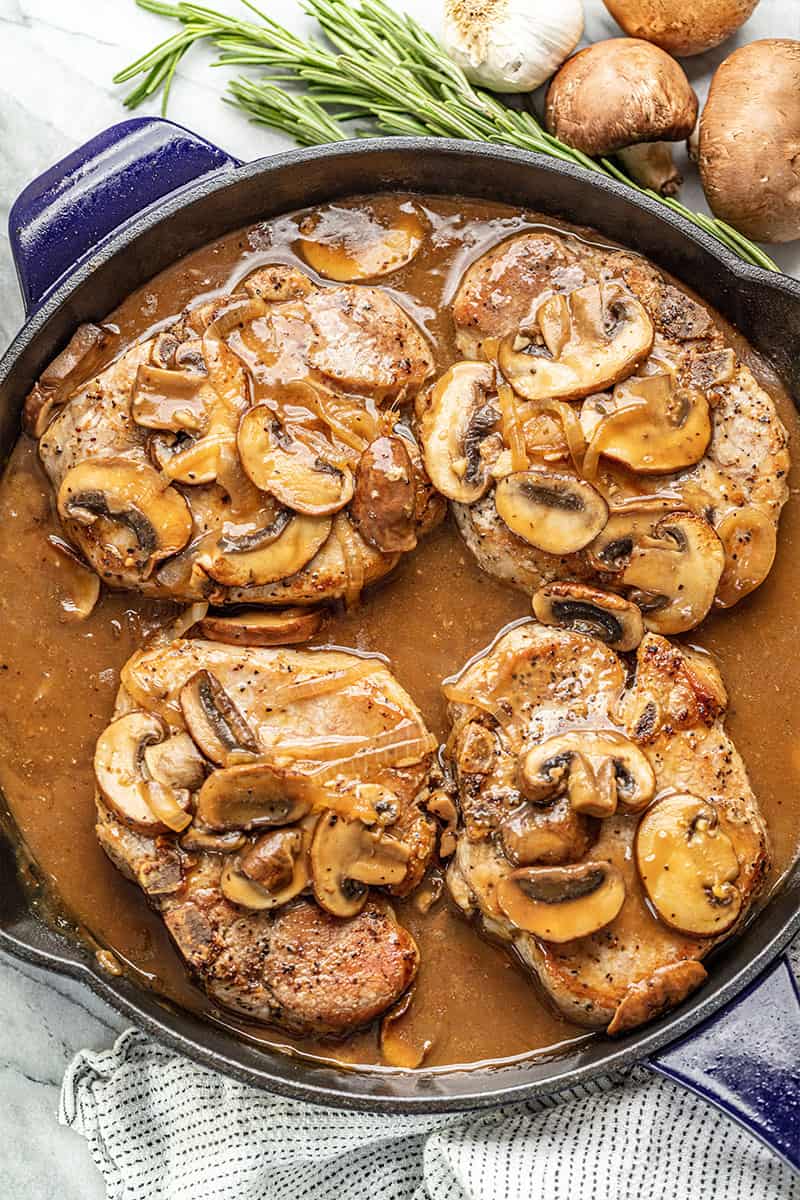 Bird's eye view of Smothered Pork Chops in a cast-iron skillet.