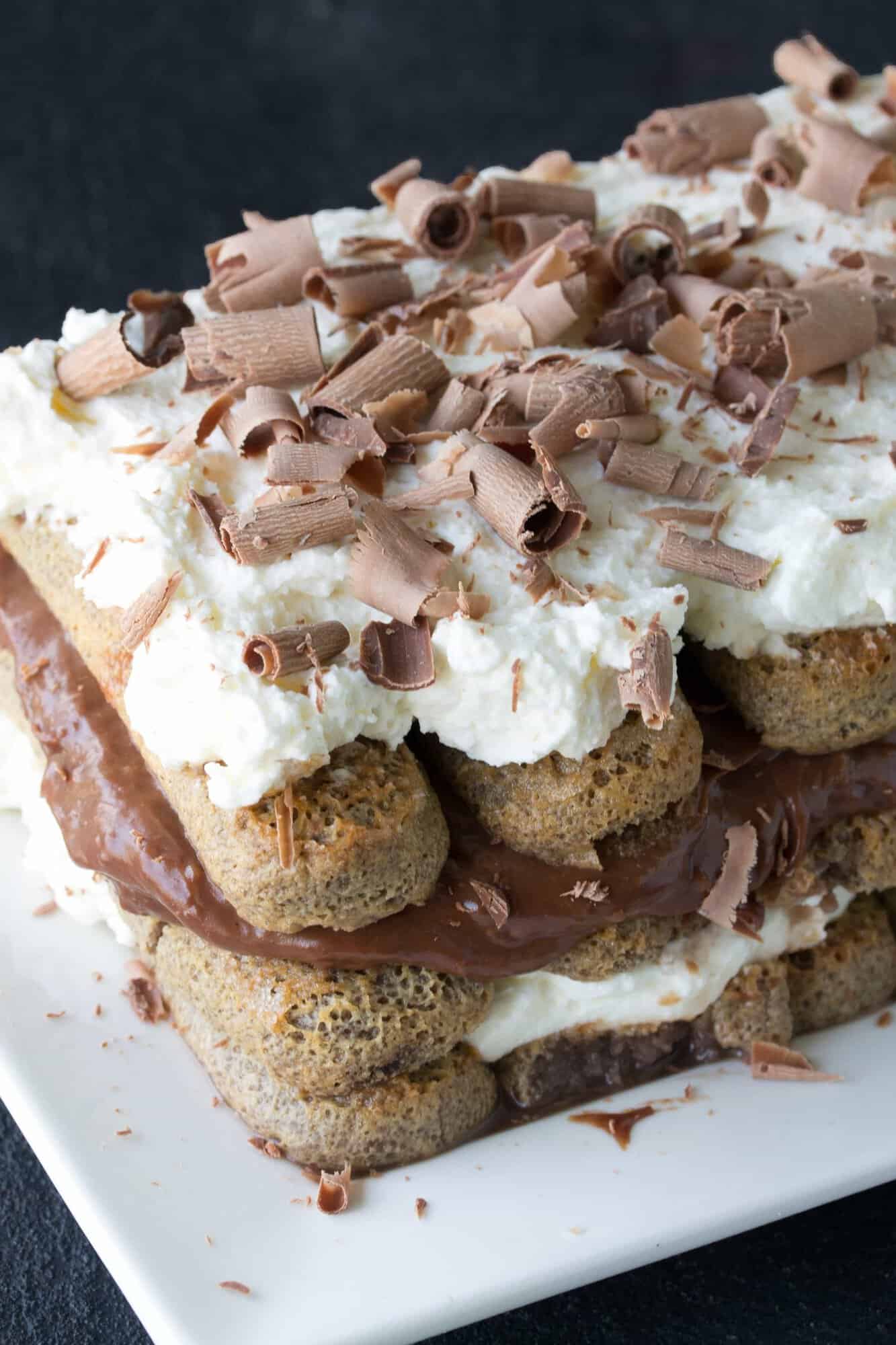 Chocolate soaked lady fingers are layered with mascarpone cream and chocolate custard and garnished with chocolate curls.