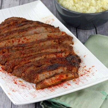 Oven Roasted Flank steak on a white serving plate.