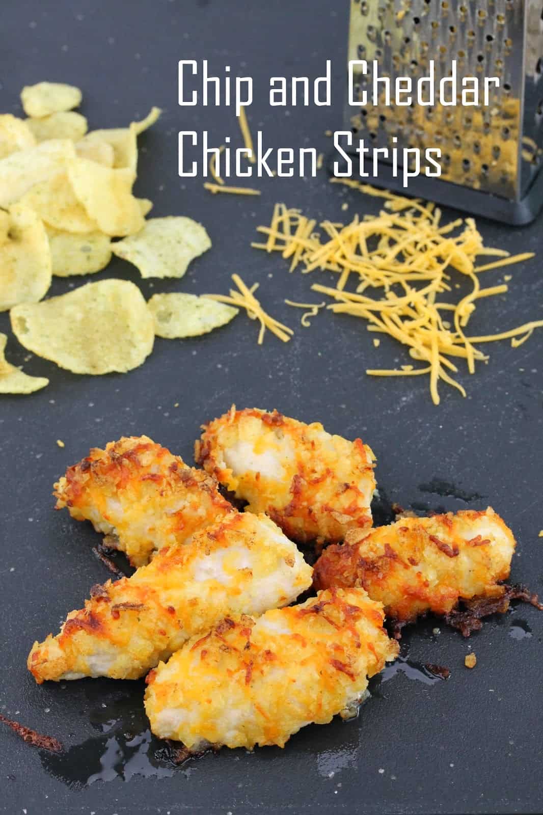 Chip and Cheddar Chicken Strips on a table with chips and cheddar cheese in the background.