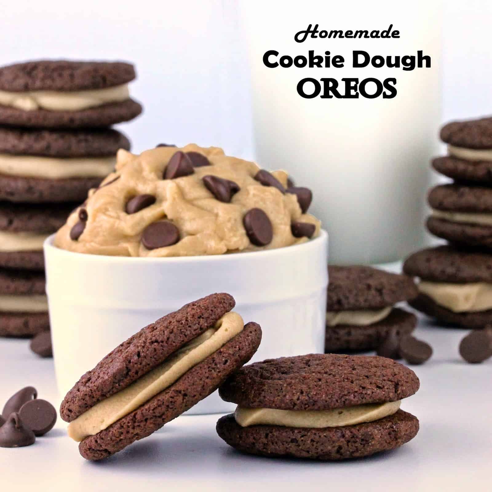 Two homemade cookie dough Oreos in front of a bowl of the filling.