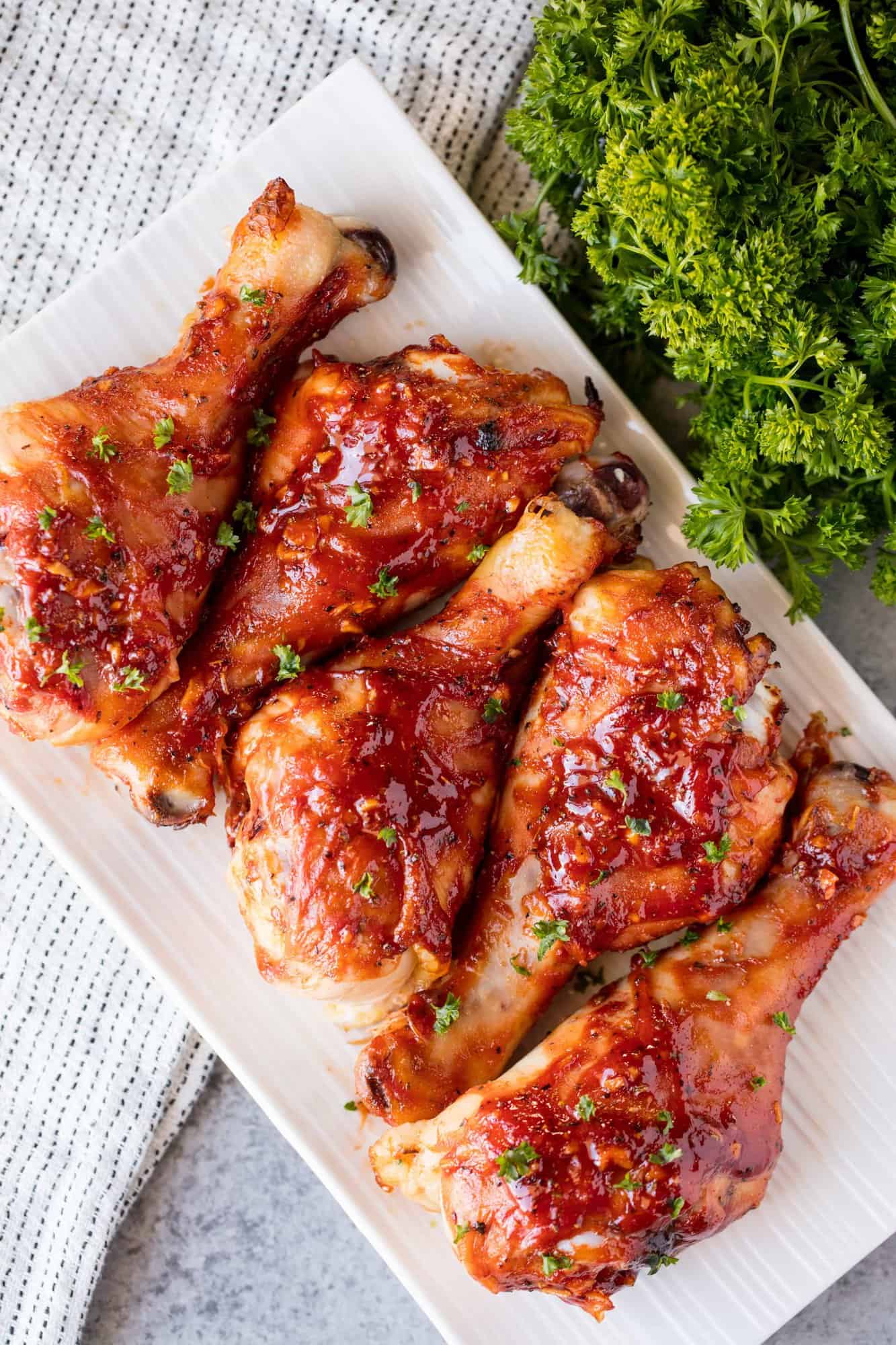 Honey Garlic Barbecue Chicken Drumsticks are finger-licking good! A homemade honey garlic barbecue sauce smothered on chicken drumsticks with a cooking hack that makes it incredibly easy!