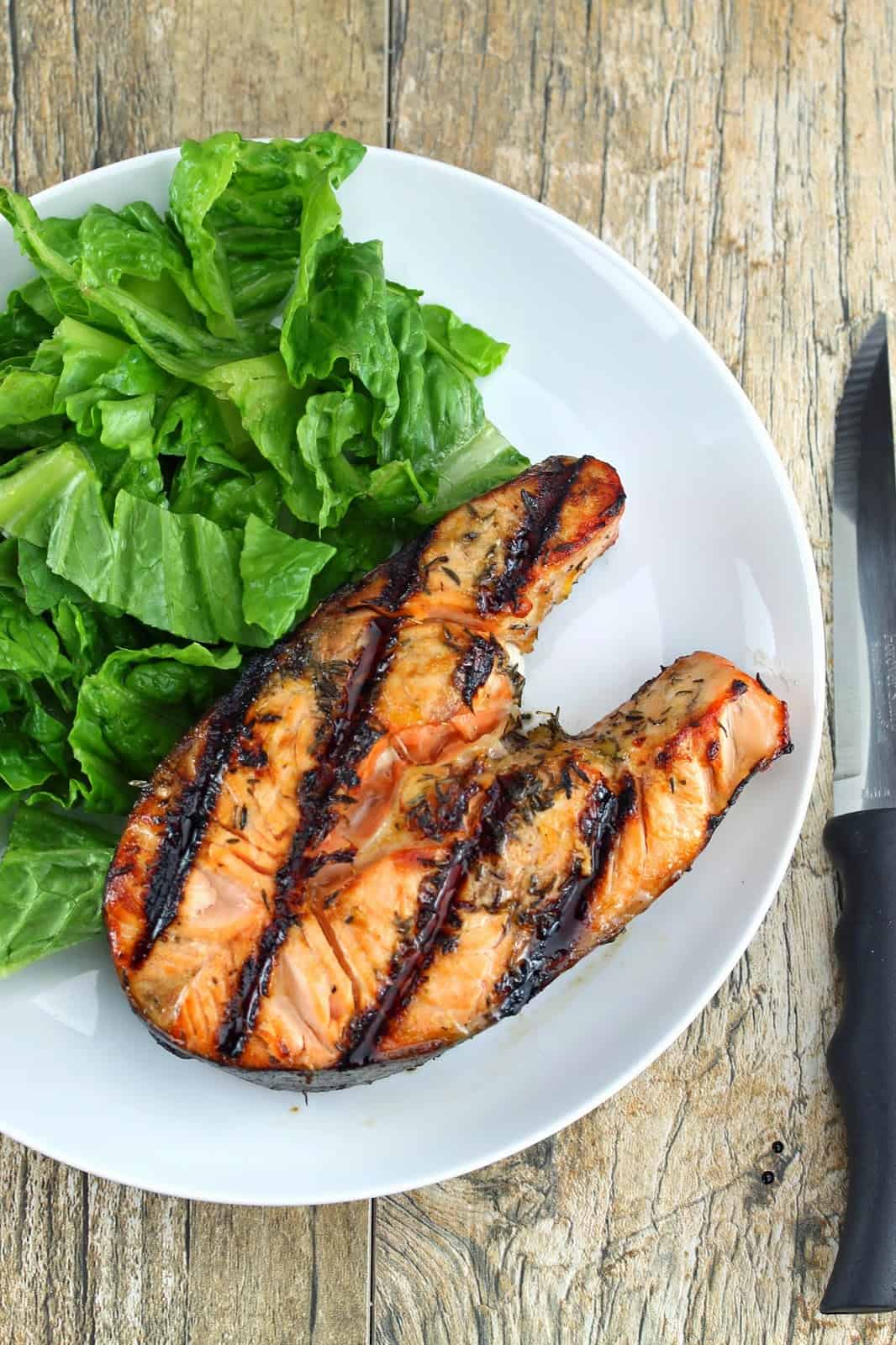 Overhead view of orange ginger salmon steak on plate with a salad