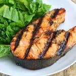 orange ginger grilled salmon steak next to salad