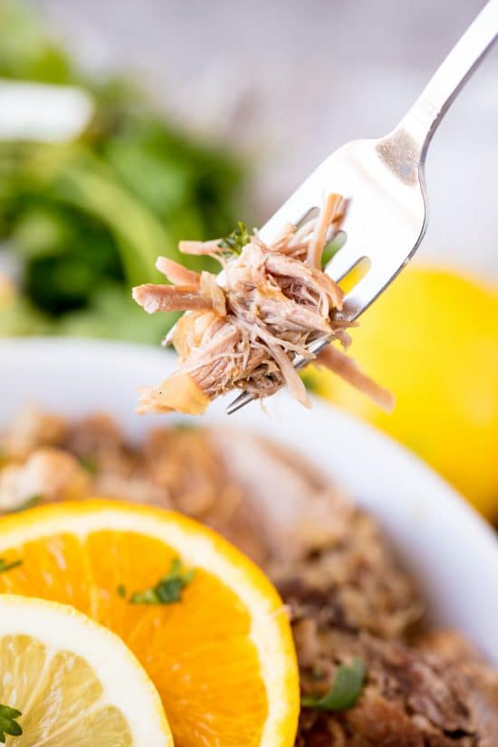 A fork lifts a bite of Slow Cooker Cuban Mojo Pork