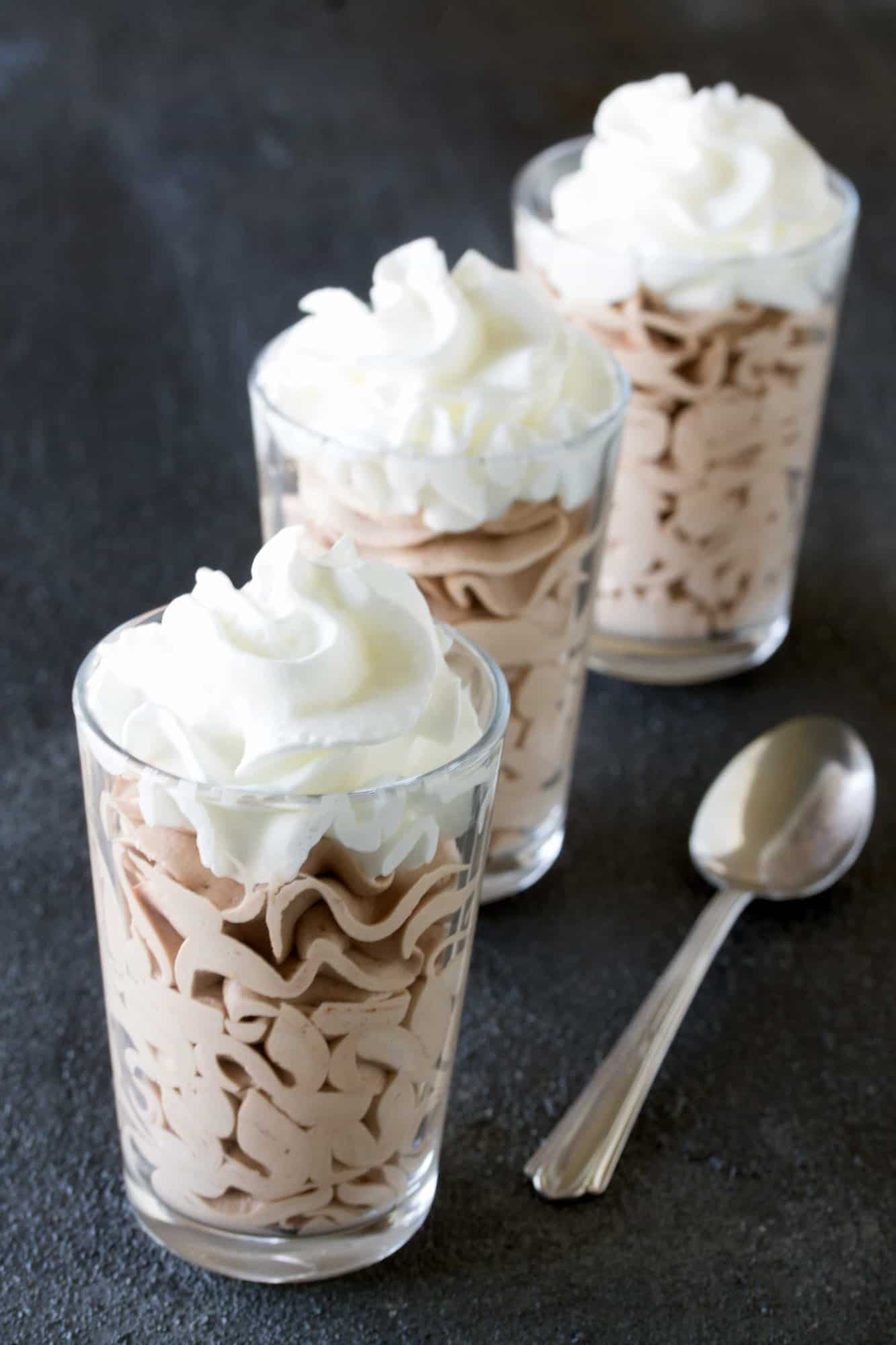 Three Nutella Mousse in glasses topped with whipped cream.