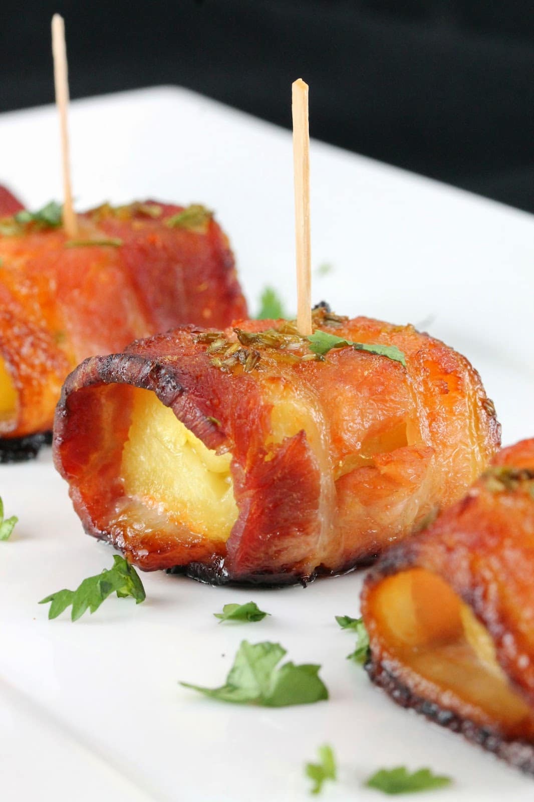 Sriracha Honey Glazed Bacon Wrapped Pineapple stuck together with a toothpick