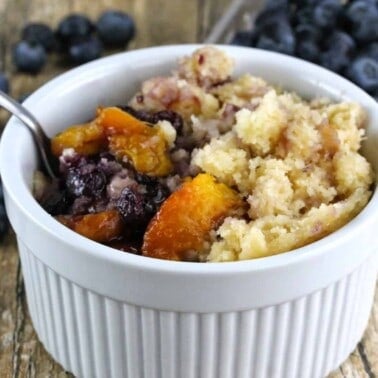 Slow Cooker Blueberry Nectarine Cobbler in a white bowl with a spoon in it.