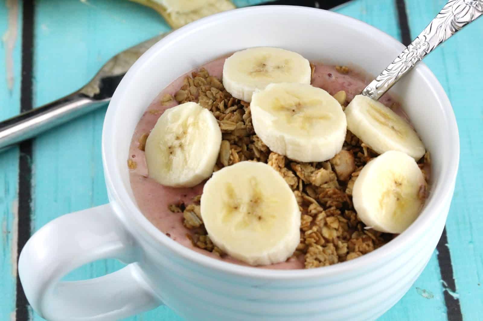 Granola with pureed strawberry and topped with sliced banana.