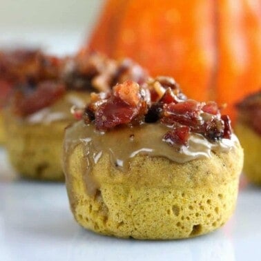 Maple Bacon Pumpkin Donut with a pumpkin in the background.