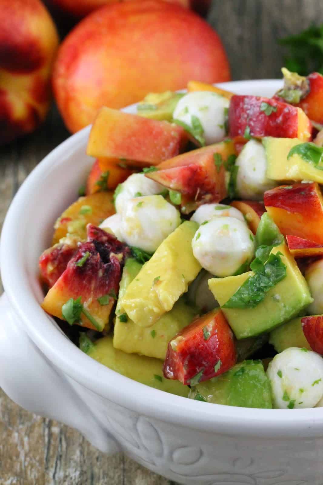 Close up of Nectarine and Avocado Fruit Salad in a white bowl
