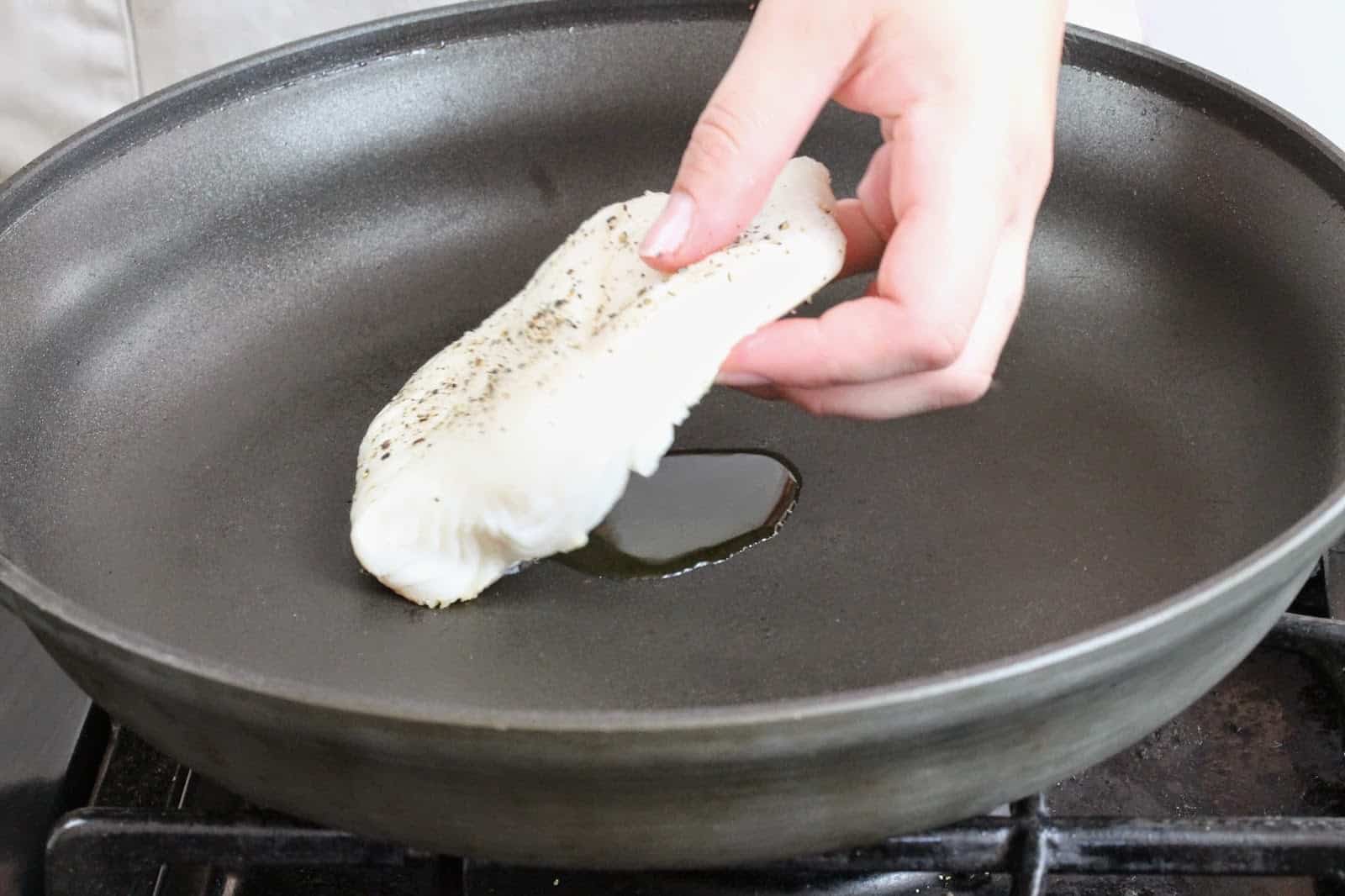 The filet is gently placed into the oil on the skillet