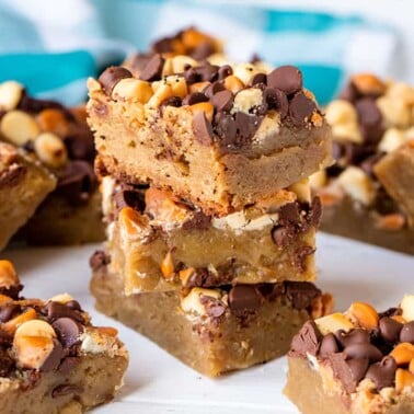 A stack of Slow Cooker Cookie Bars loaded with white chocolate, peanut butter, and chocolate chips.