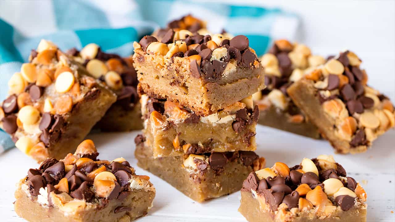 A stack of Slow Cooker Cookie Bars loaded with white chocolate, peanut butter, and chocolate chips.