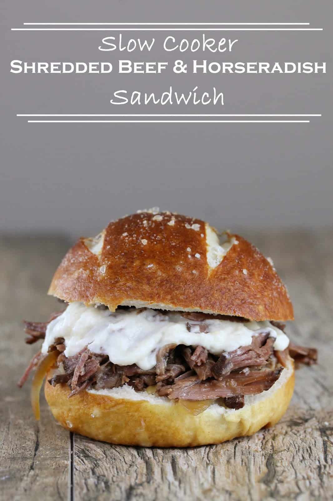 Slow Cooker Shredded Beef and Horseradish Sandwich on a wood counter with the words "Slow Cooker Shredded Beef and Horseradish Sandwich" above it.