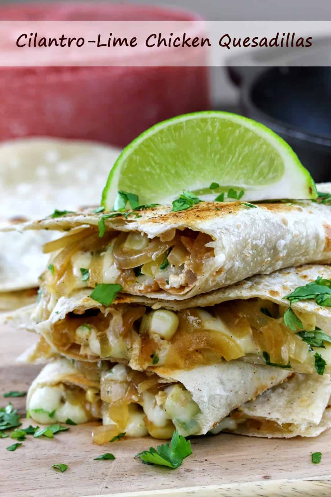 A stack of quesadillas spilling over with cheese, onions, corn and chicken and garnished with fresh cilantro and a lime wedge