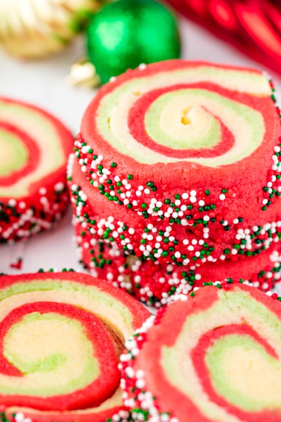 A stack of Spiral Christmas Sugar Cookies with swirls of red, green and white and rolled in green, red and white sprinkles