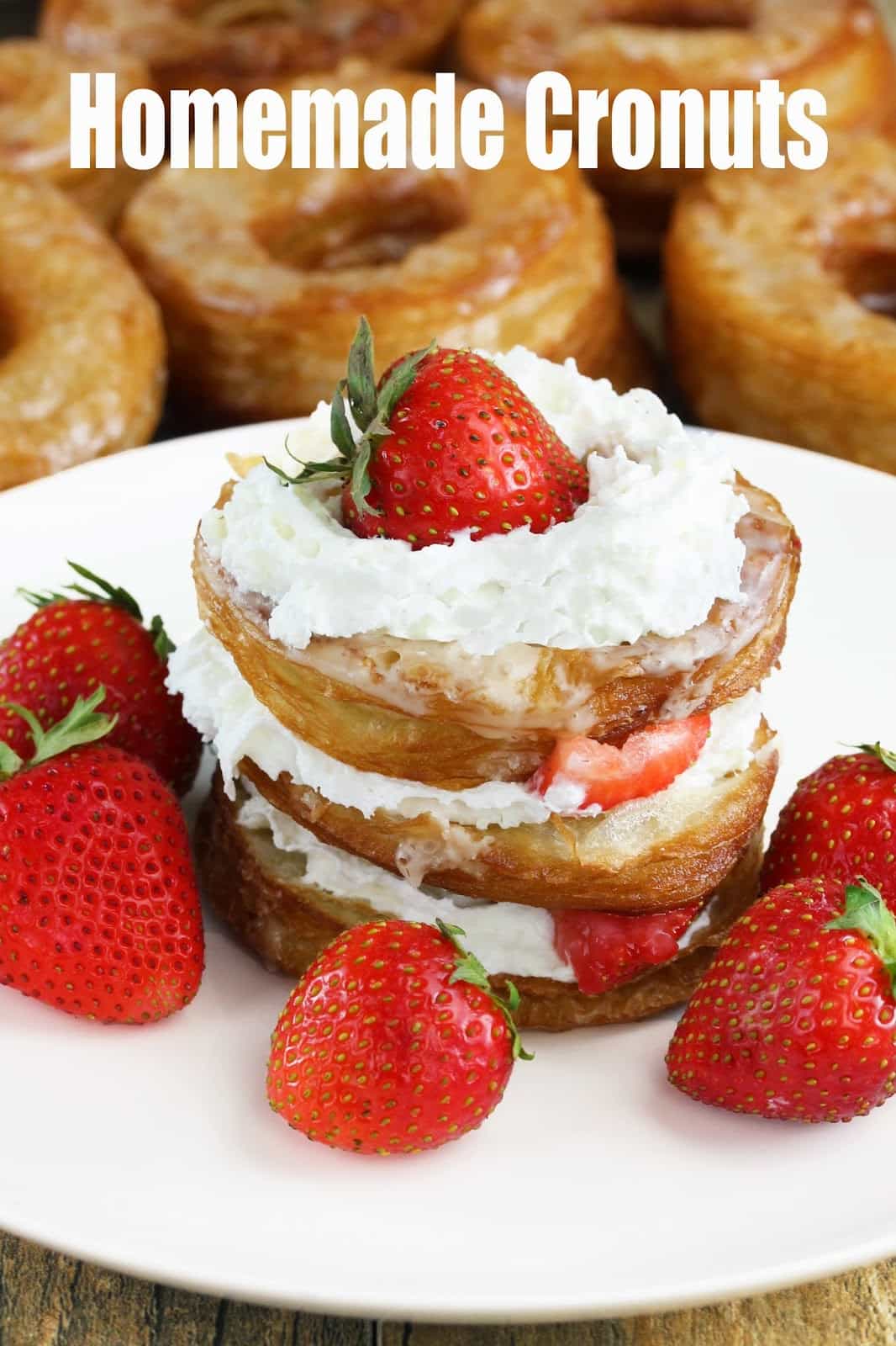 Homemade Cronuts: croissants and donuts combine for one amazing pastry called a cronut. These are shown in a stack layered with whipped cream and fresh strawberries.