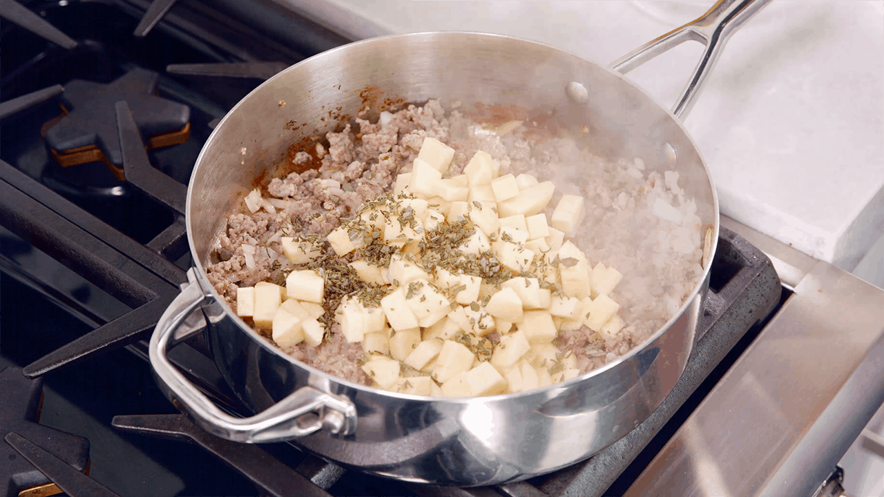 Cooking sausage, apple, and sage in a skillet