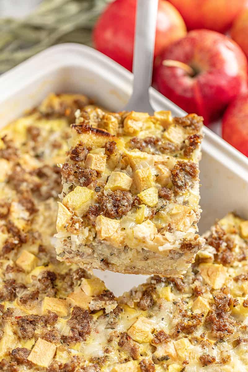 Slice of Apple and Sausage Breakfast Strata held up with a metal spatula.